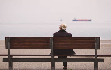 Elderly man sit on the beach in front of the beach.