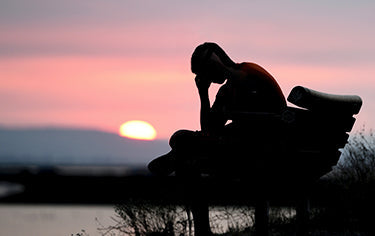 Boy feeling the mental effects siting outdoor