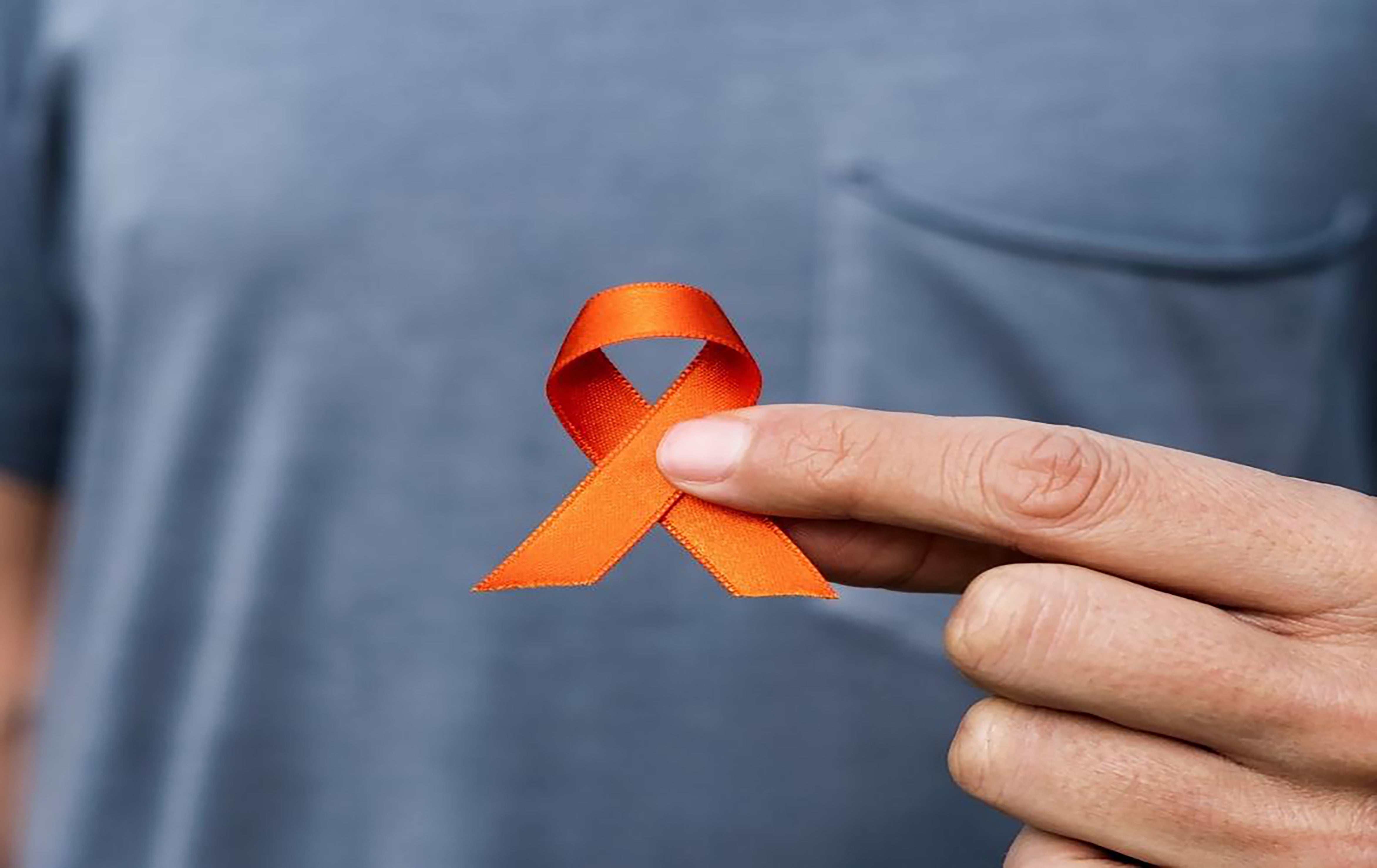 Hand hold the orange ribbon on awareness week
