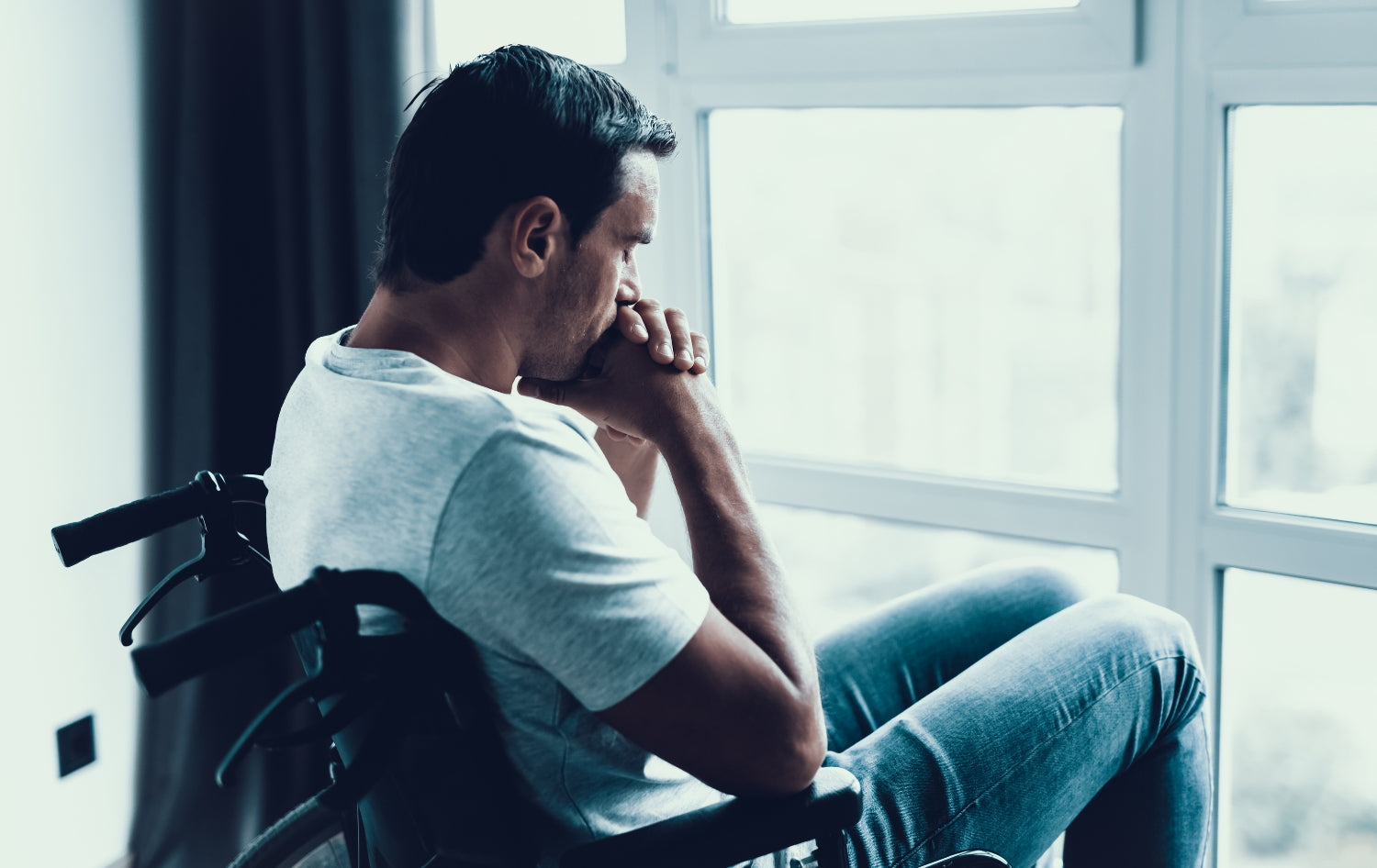 Male in wheelchair looking out the window 