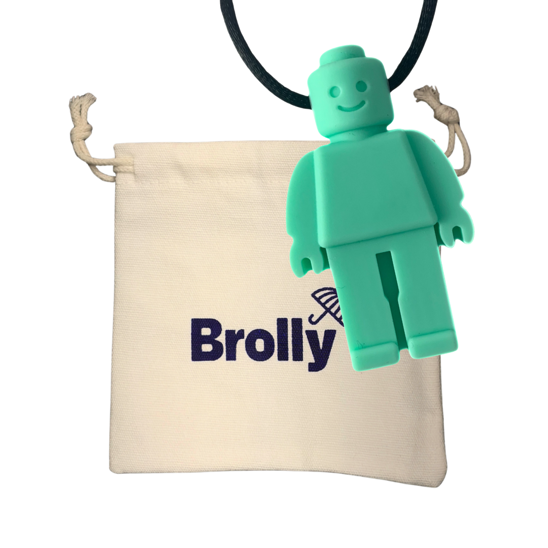Beige drawstring pouch and Robot-shaped Brolly Chew Necklace on a black cord against a white background - Teal