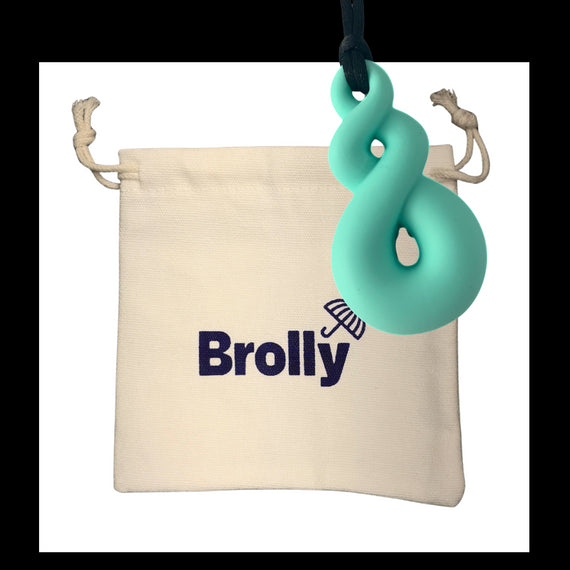 Beige drawstring pouch and Shark Tooth-shaped Brolly Chew Necklace on a black cord against a white background - Blue